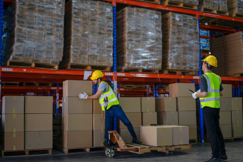 Blue collar workers are working at warehouse. Logistics, transportation.