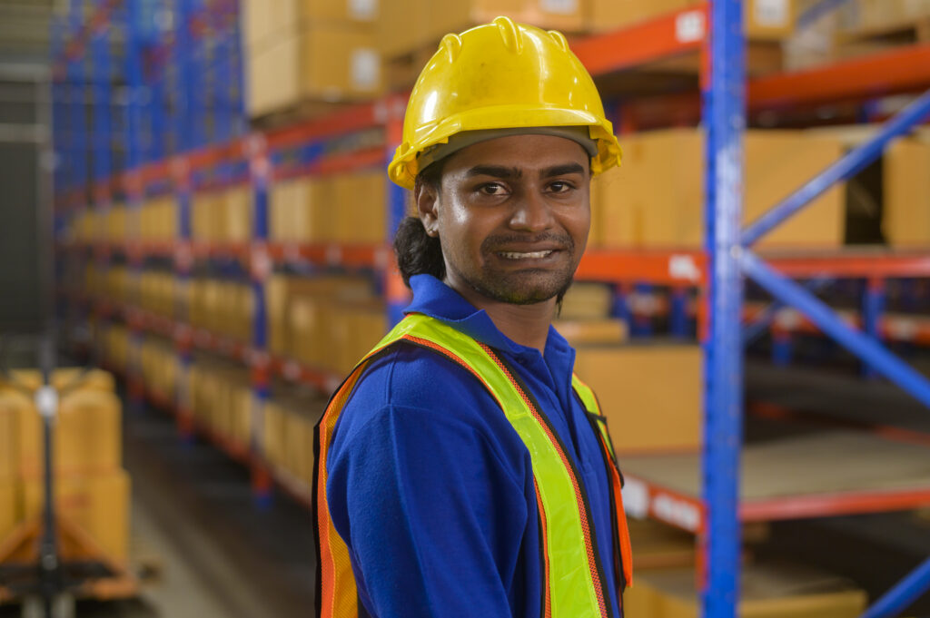 Male worker wearing helmet in warehouse storage